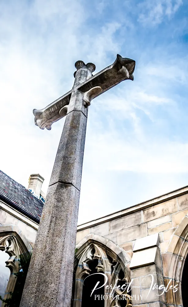 Stone cross against sky at a Gothic church cloister