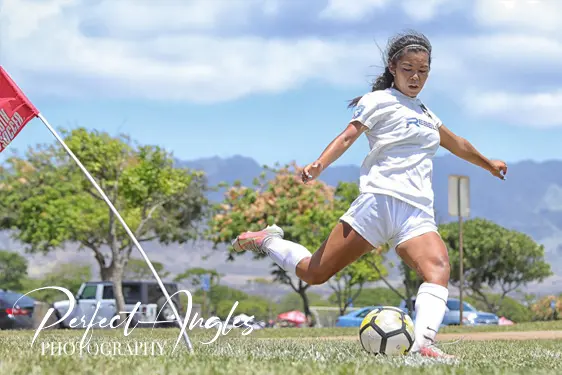 Female soccer player striking the ball