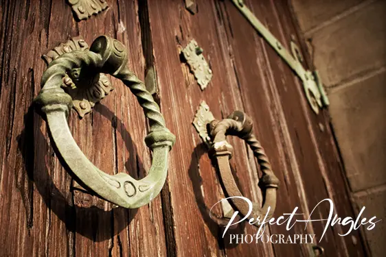 Ornate antique door knockers on a wooden door