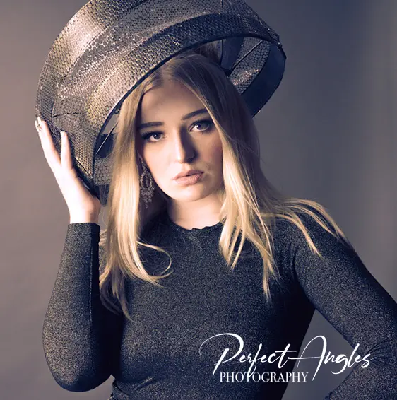 Editorial portrait of a woman in a metallic hat